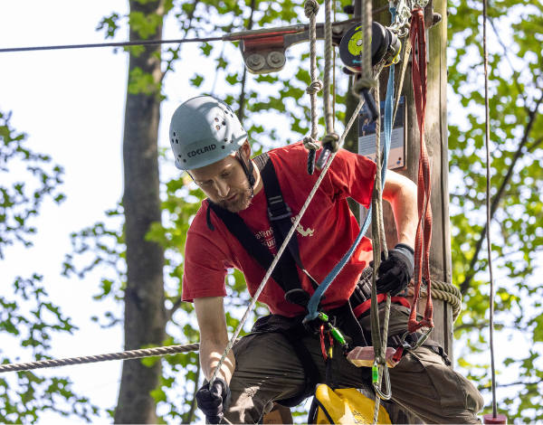 Ein Mitarbeiter pr�ft den Sitz der Kletterausr�stung bei einem Kind