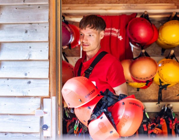 Ein Mitarbeiter pr�ft den Sitz der Kletterausr�stung bei einem Kind