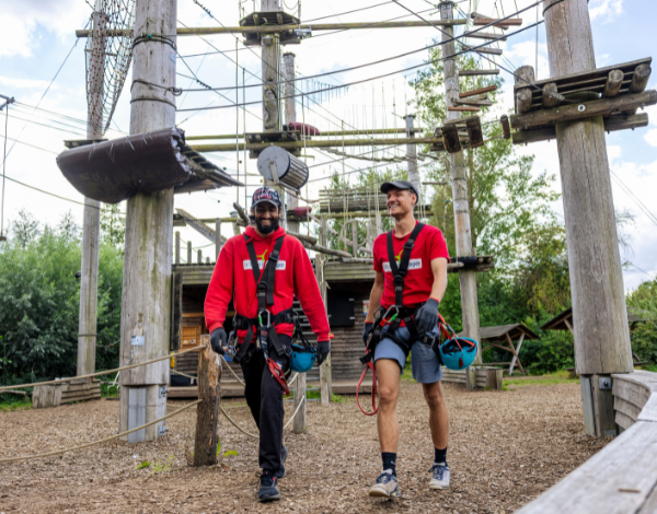 Zwei Mitarbeiter des Kletterparks stehen am Empfangstresen und l�cheln in die Kamera