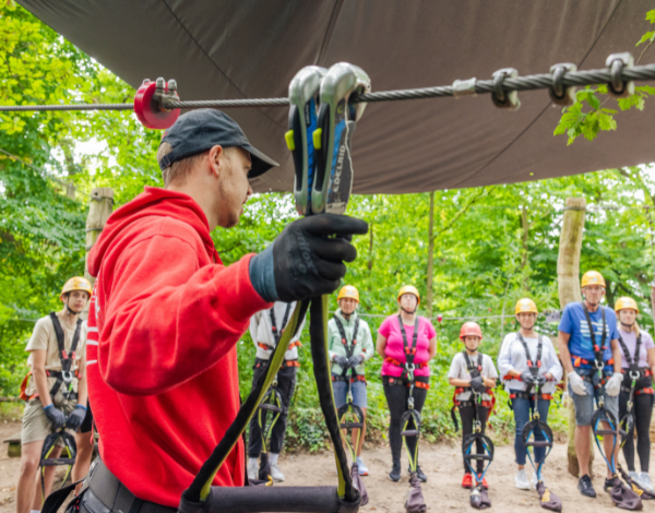 Ein Mitarbeiter pr�ft den Sitz der Kletterausr�stung bei einem Kind