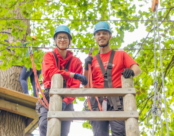 Zwei Mitarbeiter recken l�chelnd die Daumen in die H�he