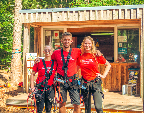 Zwei Mitarbeiter des Kletterparks stehen am Empfangstresen und l�cheln in die Kamera